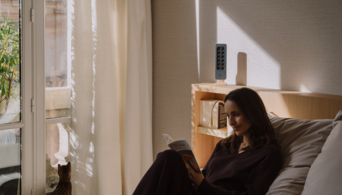 Lettura tranquilla in camera con un purificatore TEQOYA sulla mensola